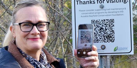 Susan Riddell shows, with her smart phone, how easy it is to donate to conservation with QR code ...