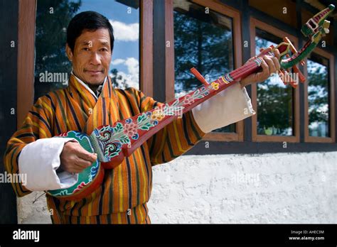 Portrait of a Bhutanese man in natiional dress wearing a warm coloured ...