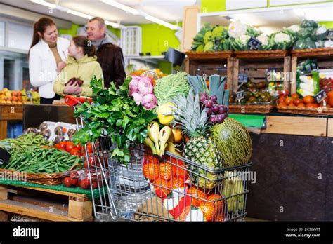 Full shopping cart in vegetables store Stock Photo - Alamy