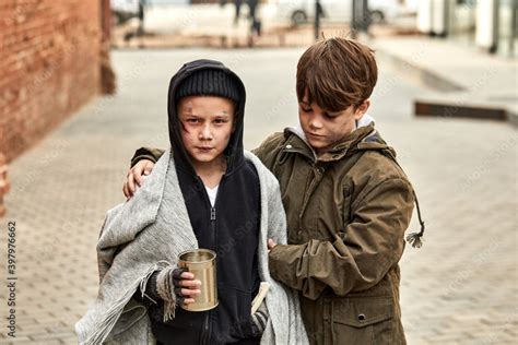 two homeless children ask for help in the street, at street in big city, begging. shelter ...