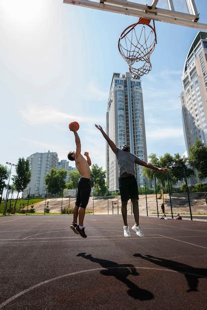 Active men playing basketball long shot Photo | Free Download