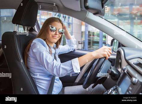 a young girl driving a car in the town Stock Photo - Alamy