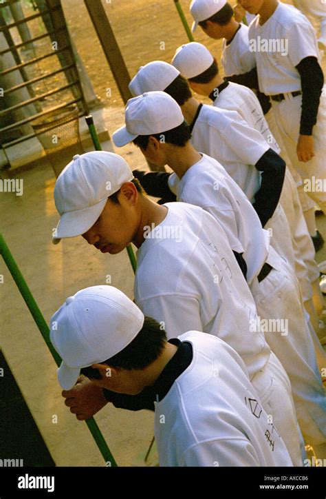 Young Japanese little league baseball players put away their equipment ...