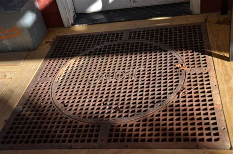 a metal grate sitting on top of a wooden floor next to a white door