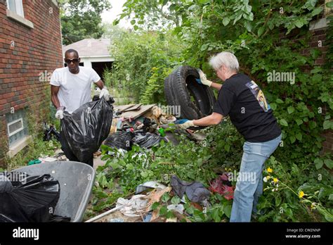 Detroit, Michigan - Members of the Three Mile Block Club cut weeds and remove illegally-dumped ...