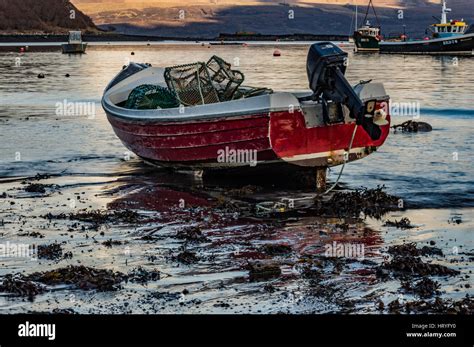 Small dinghy with outboard motor anchored in Portree Harbour, Isle of Scotland Stock Photo - Alamy