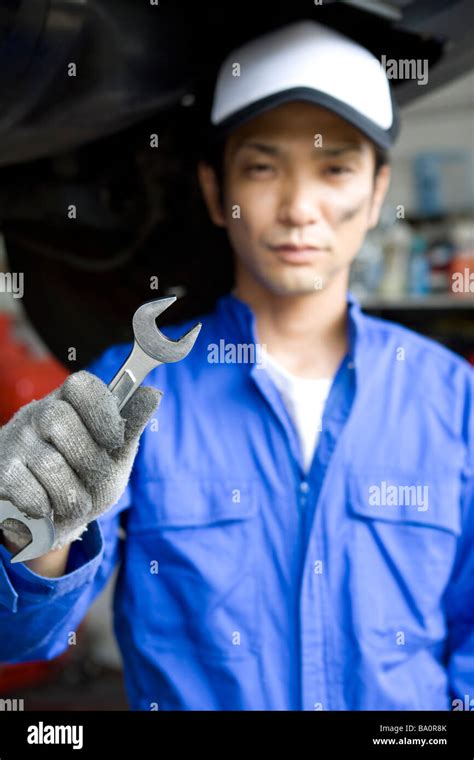 Mechanic holding wrench Stock Photo - Alamy