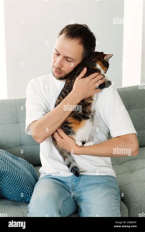 Depressed man hugging cat. Tired unhappy stressed male cuddling with ...