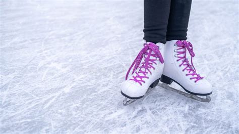 Legs of a Girl in White Figure Skates with Purple Laces on an Outdoor Skating Rink in the Park ...