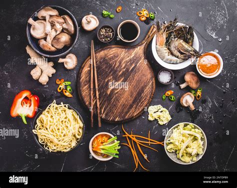 Asian food cooking concept. Empty wooden board, noodles, vegetables ...