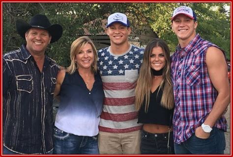 three men and two women are posing for the camera with an american flag shirt on