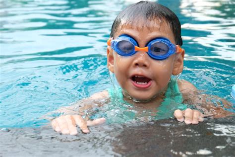 Toddler Swimming on Pool Wearing Blue Goggles · Free Stock Photo