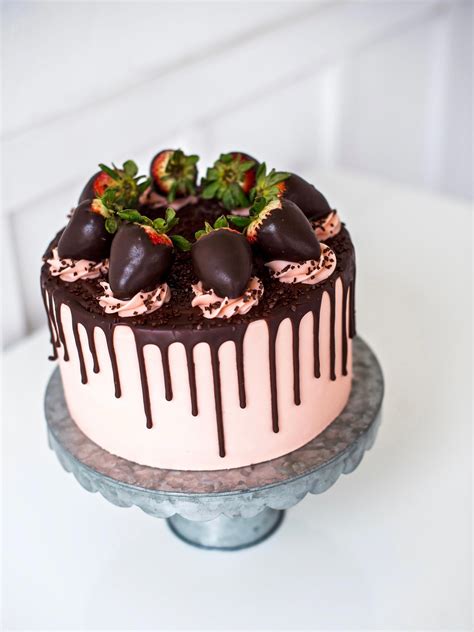 Layers of dark chocolate cake with strawberry buttercream, fresh strawberries and chocolate gana ...