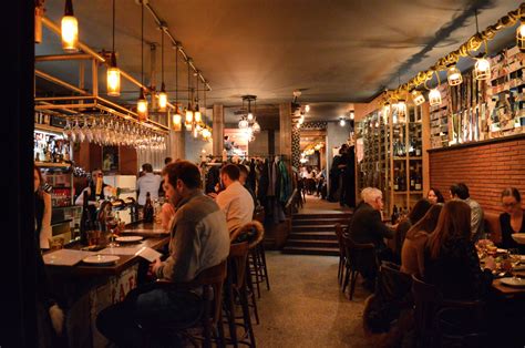 people are sitting at tables in a bar