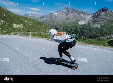 Cinematic downhill longboard session. Young woman skateboarding and ...