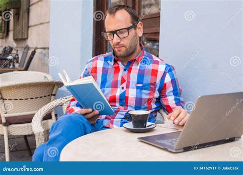 Man Is Reading A Book In Cafe. He Is Drinking Coffee. Stock Image - Image: 34162911