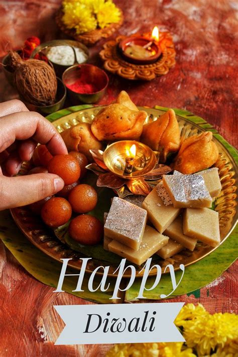 happy diwali greeting card with food on plate and candles in the ...