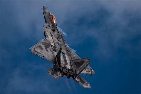 An F-22 Raptor aircraft performs a 'tail slide' maneuver during an ...