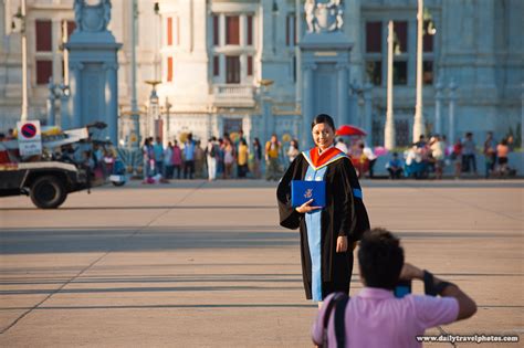 Advanced Degree - A newly minted university graduate poses for a photo in front of the Ananta ...