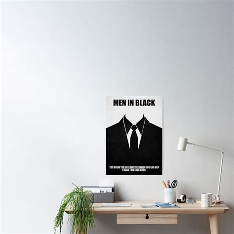 a poster with the words men in black on it sitting on a desk next to a ...