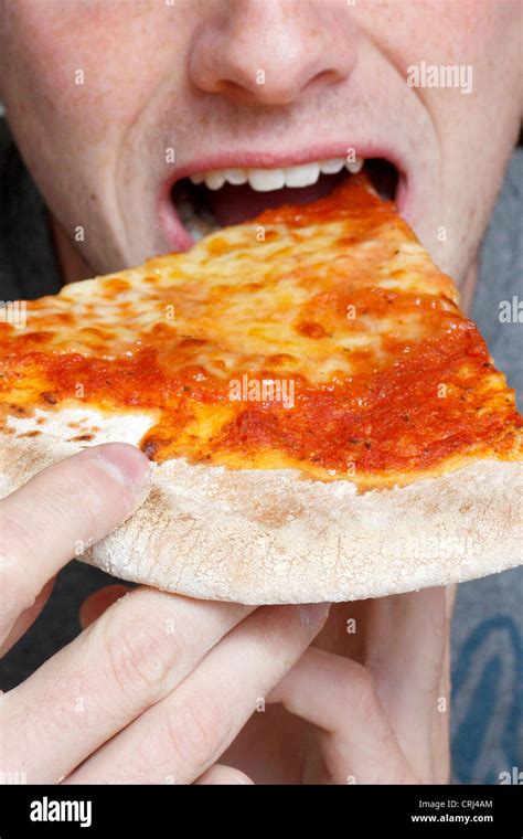 Man eating a pizza slice Stock Photo - Alamy