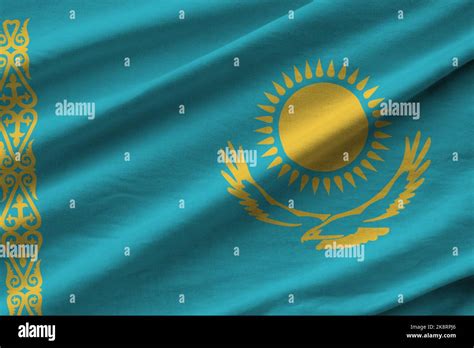 Kazakhstan flag with big folds waving close up under the studio light indoors. The official ...