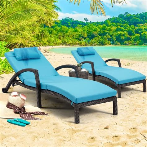 two chaise lounge chairs sitting on the beach