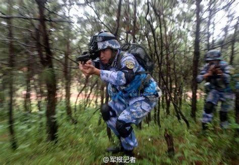 Chinese marines wear blue battle fatigues in green vegetation