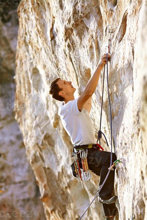 Rock climber climbing up a cliff 714678 Stock Photo at Vecteezy