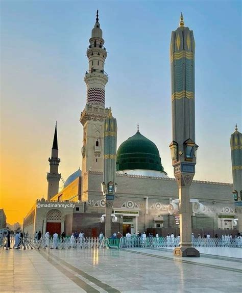 a large white building with two green domes on it's sides and people walking around in the ...