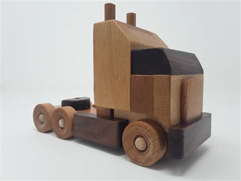 a wooden toy truck is shown on a white background