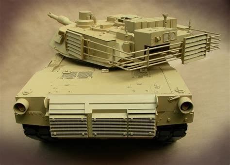 a toy model of a tank on a white surface with a black background behind it