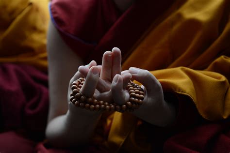 Hands of nun praying at teachings .:. Tibet Sun