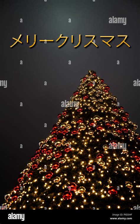 A Christmas tree with golden and red decoration. The Japanese text „メリー ...