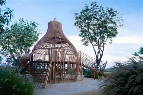 a wooden play structure surrounded by trees and grass