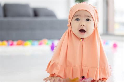 Premium Photo | Muslim Baby plays with colorful toys in the living room