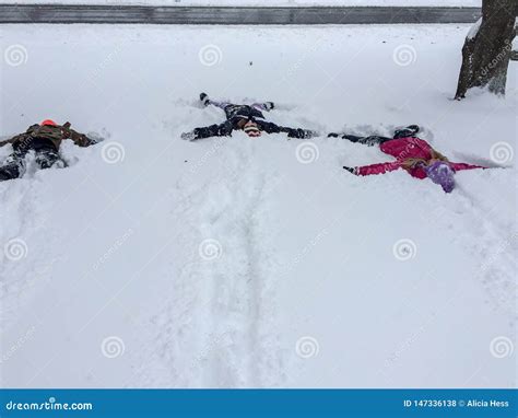 Three Kids Making Snow Angels Stock Photo - Image of tree, gloves: 147336138