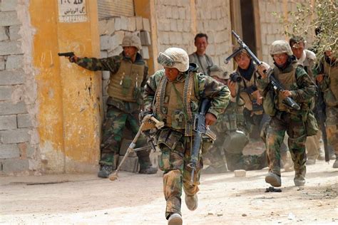 United States Marines of 3rd Battalion, 4th Marines crossing a street on the outskirts of ...