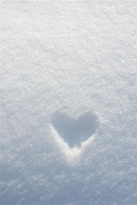 Premium Photo | Heart shape painted on white snow background. frozen heart. snow valentine ...