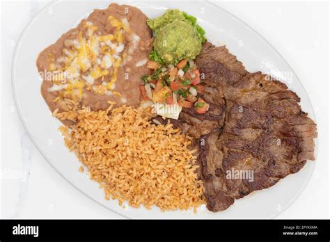 Overhead view of carne Asada steak cooked to perfection and served with rice and beans on a ...