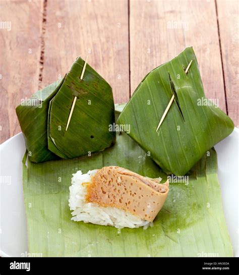 Thai Dessert - Sticky Rice with Egg Custard warpped by banana leaf on white dish Stock Photo - Alamy