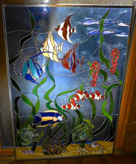 a stained glass window with fish and seahorses in the water on it's side