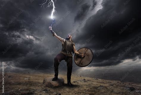 Medieval warrior berserk Viking with axe catch the lightning. Concept ...