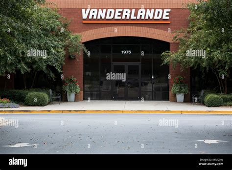 A logo sign outside of a facility occupied by Vanderlande Industries in ...