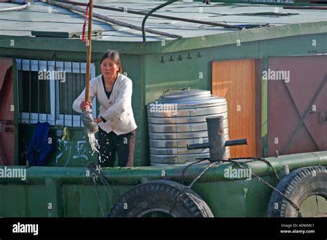 A woman wring out a mop after washing the deck of a Chinese barge in Shanghai China Stock Photo ...