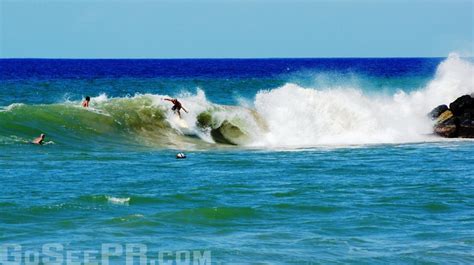 two surfers are riding the waves in the blue ocean, one is falling off his surfboard