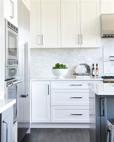 white shaker panel cabinets + dark grey island + marble backsplash | White shaker kitchen ...