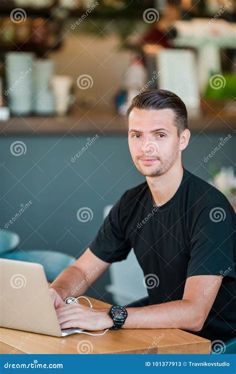 Young Man with Laptop in Outdoor Cafe Drinking Coffee. Man Using Mobile Smartphone. Stock Image ...