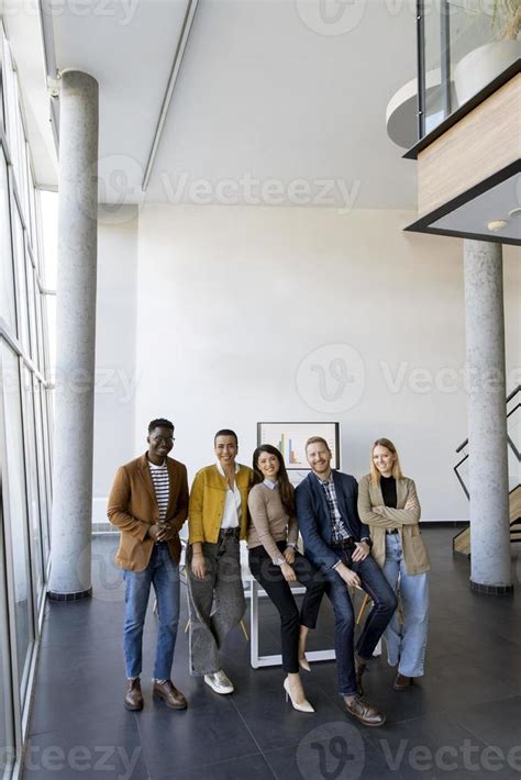 Group of positive businesspeople standing together in the office ...