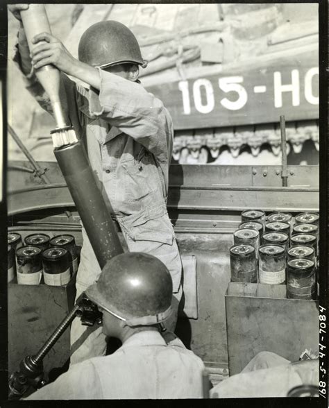 A gunner of 81mm mortar prepares to drop a mortar shell into tube ...